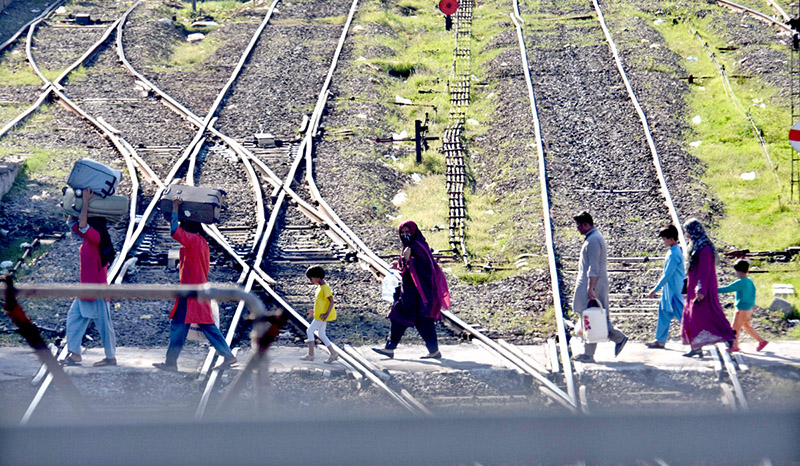 Passengers carry their luggage as they arrive at the railway station to depart for their hometowns to celebrate the Eid al-Fitr with their loved ones