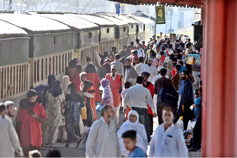 Passengers carry their luggage as they arrive at the railway station to depart for their hometowns to celebrate the Eid al-Fitr with their loved ones