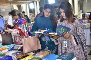 Women selecting books from the annual book fair at Custom House DC Road.