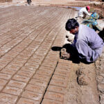 A gypsy family preparing mud bricks at a kiln