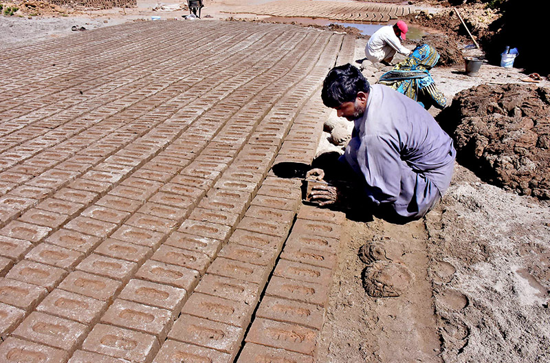 A gypsy family preparing mud bricks at a kiln