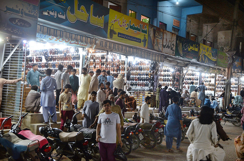People selecting Peshawari sandals from vendor in preparation of upcoming Eid ul fitr at Bacha Khan Market