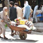 An aged person carrying cold drinks and other items on his handcart to supply at Qissa Khawani Bazar