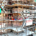 Labourers busy in restoration work on the wall of historical Shahi Qila