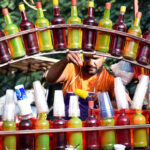 A vendor busy in preparing and selling the ice-lolly for customers on his hand cart setup outside the Sheranwala Gate.