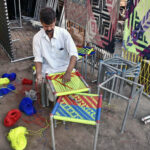 A worker busy in knitting the traditional stool and traditional bed (Charpai) for customers at his workplace