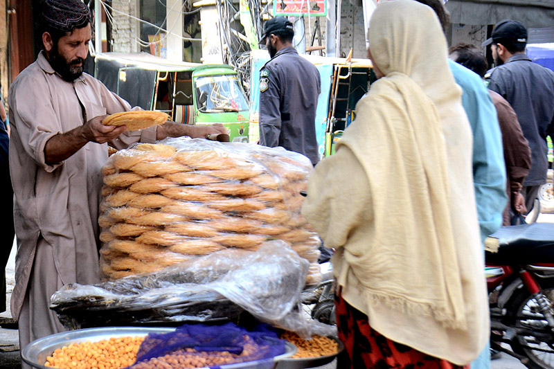A shopkeeper is setting up a stall of traditional food item before breaking the fast