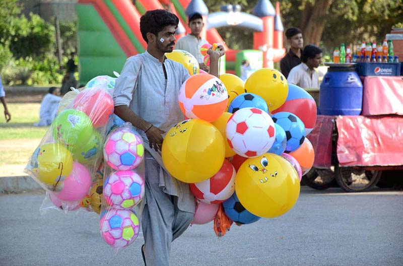 A vendor selling balloons in a local park.