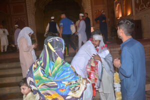 People receive the devotees after completing Itikaf outside a mosque in the last night of Ramadan