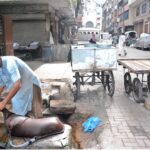 A person busy in filling “mashk” (container used for carrying or storing water) to deliver to residents of Saddar area.