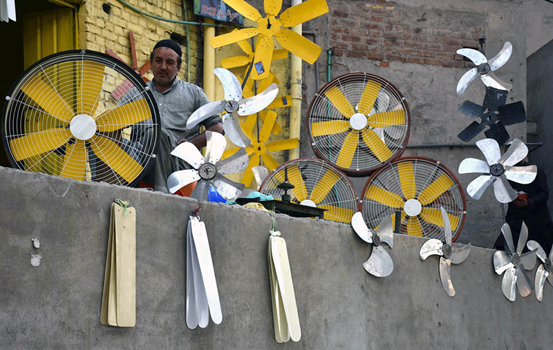A worker busy in preparing air cooler fans blades at his workplace.