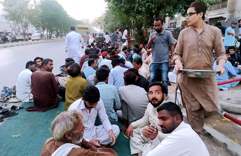 Volunteers serving food items for people in fast during Iftar in the holy Islamic fasting month of Ramzan ul Mubarak at road side