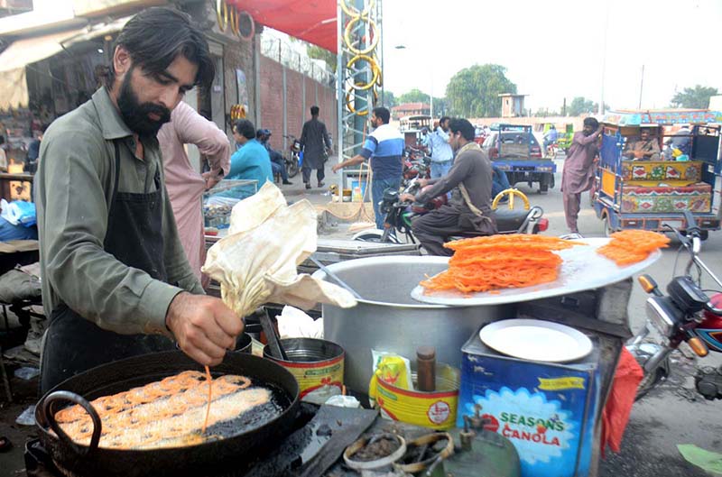 A vendor preparing traditional sweet item (Jalaibe) to sell at his roadside setup