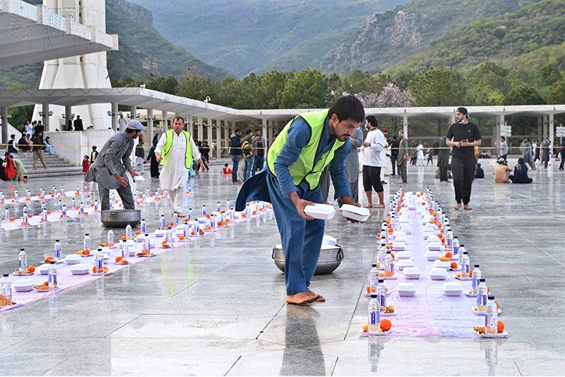 Volunteers arranging food items during Iftar for people in fast at Faisal Masjid in the federal capital