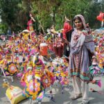 A gypsy woman vendor displaying and selling handmade toys for children at roadside setup to earn livelihood.