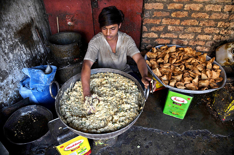 A worker preparing traditional food stuff outside his shop during Holy Fasting Month of Ramzan