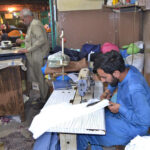 Tailors stitching clothes at his workplace Islampura as per increased flow of customers ahead of Eid Al-Fitr