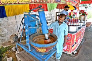 A vendor busy in preparing traditional summer drink (Sardai) for customers at his roadside setup in Federal Capital