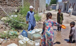 Children filling their pots with water from a house at Tarlai.