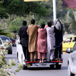 People hanging on the passenger van risking their lives at Satra Meel area on the outskirs of Islamabad, need the attention of the concerned authorities