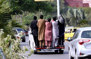 People hanging on the passenger van risking their lives at Satra Meel area on the outskirs of Islamabad, need the attention of the concerned authorities