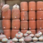A vendor arranging and displaying clay pots outside his shop at Gwalmandi to attract the customers.
