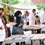 A woman selecting old books from a roadside stall at Mall Road