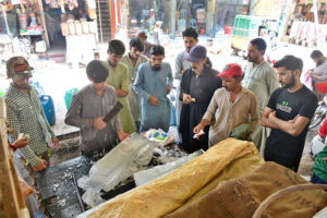 People purchasing ice from vendor during hot weather in the city.