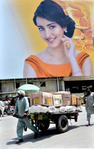 A labourer pulling handcart loaded with luggage to deliver in a local market at Raja Bazaar.