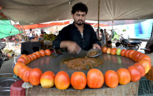 A vendor preparing traditional food to attract customers at roadside in the Federal Capital.