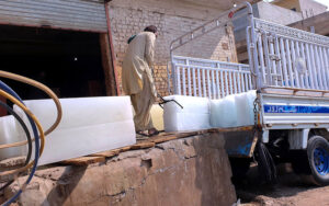 A worker loading ice blocks from an ice making factory to deliver to shops during a hot weather at Tarlai