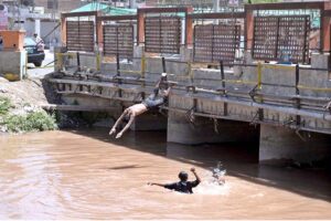 Youngsters jumping and bathing in canal to get some relief from scorching hot weather in the city.