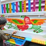 Painters busy in making painting on body of a delivery truck at Pirwadhai