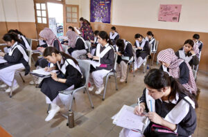 Students solving question paper during annual examination of SSC (part-I) (class IX) at Hayat Girls High School.