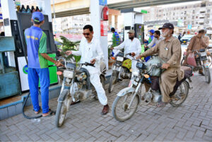 Motorcyclists waiting for their turn to fill fuel in their bikes at petrol pump after fuel prices decrease.