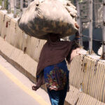A woman on the way carrying a huge bundle on her head