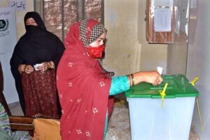 A woman casts her vote at a polling station during by-election in constituency NA-148