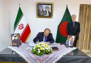 Chairman Prime Minister's Youth Programme Rana Mashhood Ahmed Khan signing condolence book at the Iranian Embassy in Dhaka, Bangladesh. Iranian Ambassador is standing next.