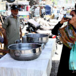 A woman drinking water at heatstroke relief camp at Hyder Chowk to get relief from hot weather in the city