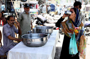 A woman drinking water at heatstroke relief camp at Hyder Chowk to get relief from hot weather in the city