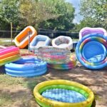 A vendor arranging and displaying bathtub for children to attract the customers at his roadside setup in Federal Capital
