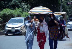 Students on the way under an umbrella to protect themselves from direct sunlight during hot weather.