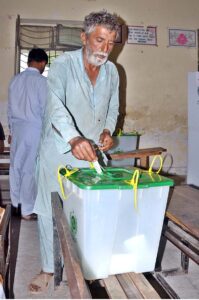 A woman casts her vote at a polling station during by-election in constituency NA-148