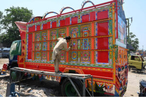 A painter busy in painting the body of a delivery truck at his workplace at Pirwadhai IJP road.