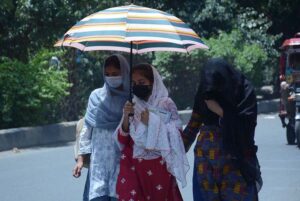 Students on the way under an umbrella to protect themselves from direct sunlight during hot weather.
