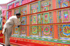 A painter busy in painting the body of a delivery truck at his workplace at Pirwadhai IJP road.