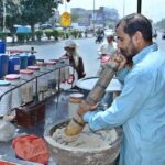 A vendor busy in preparing traditional summer drink (Sardai) for customers at his roadside setup.