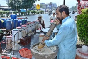 A vendor busy in preparing traditional summer drink (Sardai) for customers at his roadside setup.