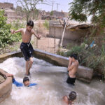 Youngsters bathing in Tube Well to get some relief from hot weather in the city