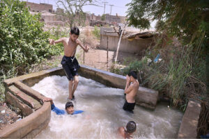 Youngsters bathing in Tube Well to get some relief from hot weather in the city